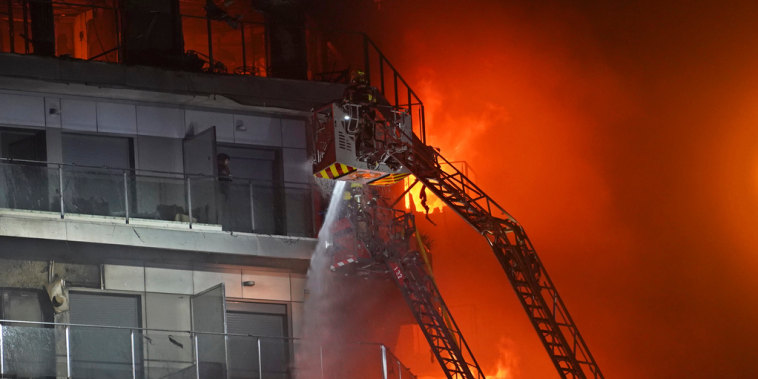 Una persona espera ser rescatada en un balcón de un edificio en llamas, en Valencia, España, el 22 de febrero de 2024.
