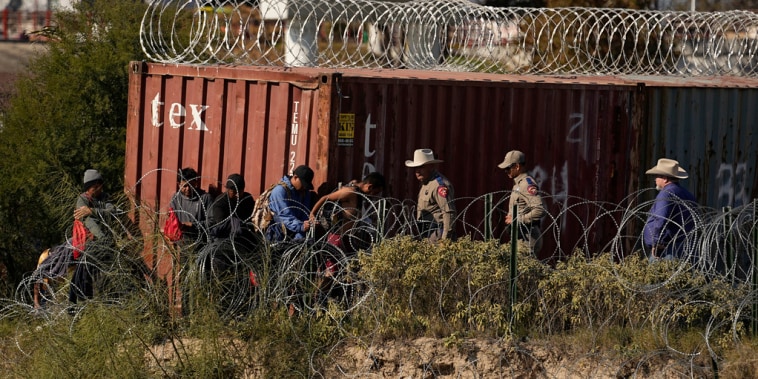 Miembros del Departamento de Seguridad Pública de Texas ayudan a guiar a migrantes al área de procesamiento luego de que cruzaran el Río Grande desde México el 3 de enero de 2024. 