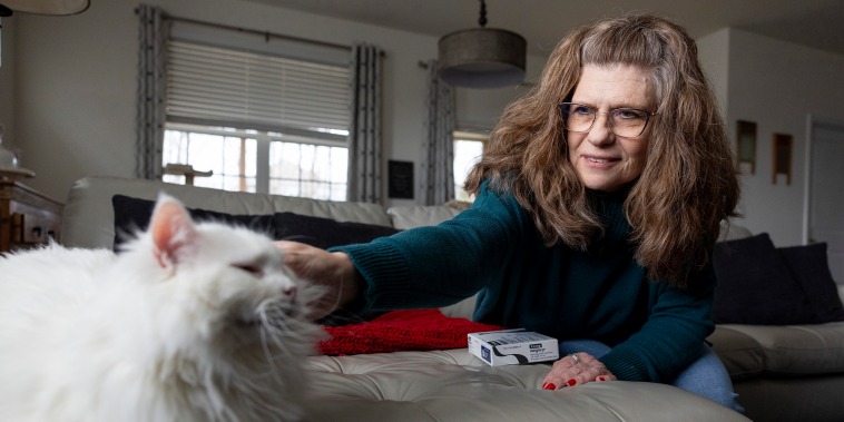 Donna Cooper pets her cat Cade at her home in Front Royal, Va., on Friday, March 1, 2024. Cooper has heard that people gain back weight when they stop using drugs like Wegovy, but she hopes to be an exception.