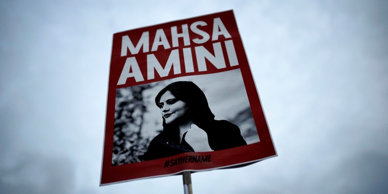 A woman holds a placard with a picture of Iranian woman Mahsa Amini during a protest.