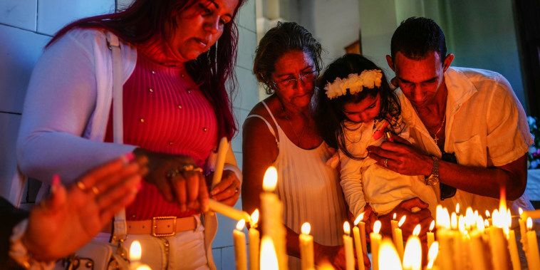 People light candles at El Cobre shrine in Cuba