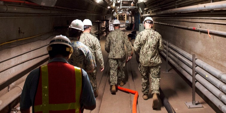 Navy and civilian water quality recovery experts walk through the tunnels of the Red Hill Bulk Fuel Storage Facility, near Pearl Harbor, Hawaii, on Dec. 23, 2021.
