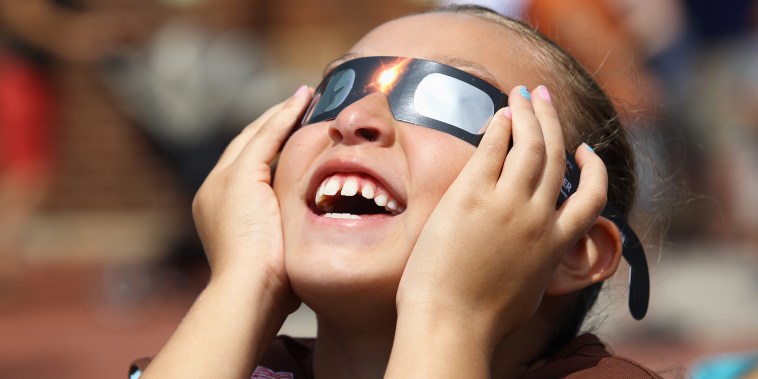 A girl looks skyward during a partial eclipse