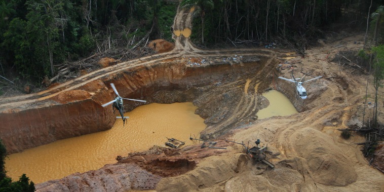 A Brazil Environmental Agency helicopter flies over an illegal mining camp