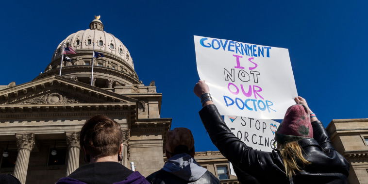 A protester holds a sign that reads, "Government is not our doctor"