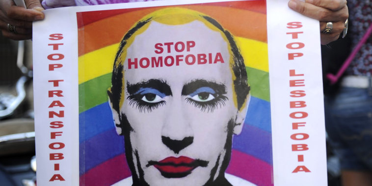 A demonstrator holds a poster depicting Russian President Vladimir Putin with make-up during a protest