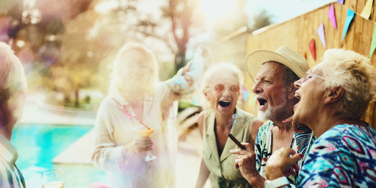 Group of carefree mature friends having fun while dancing and singing on a party during summer day by the pool.