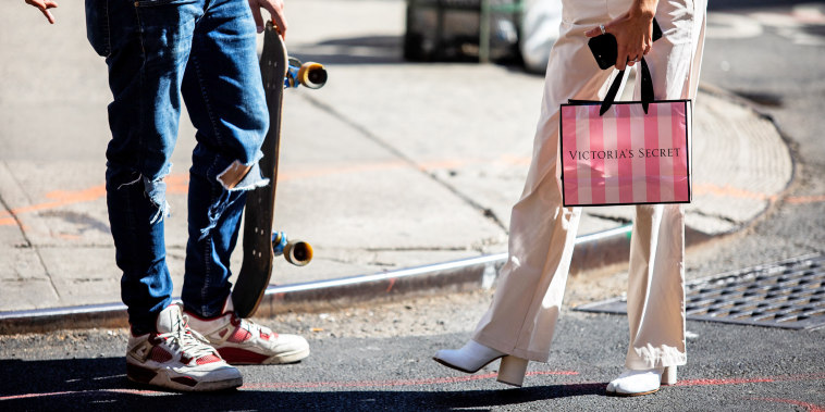 A pedestrian carries a Victoria's Secret shopping bag while waiting to cross a street in New York.