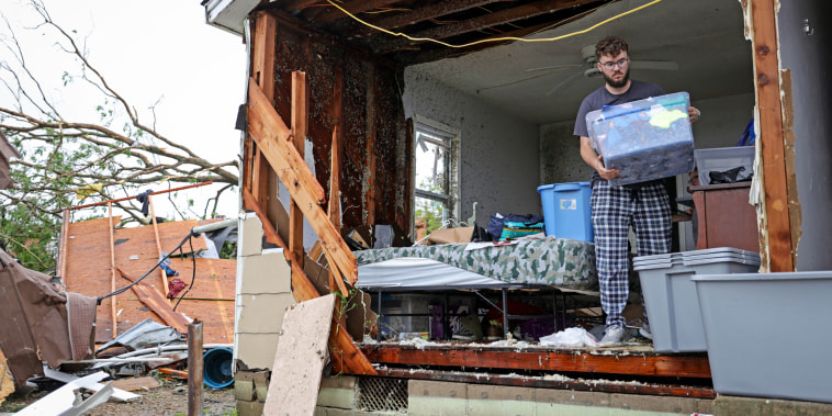 Sean Thomas Sledd salvages items from his room after it was hit by a tornado