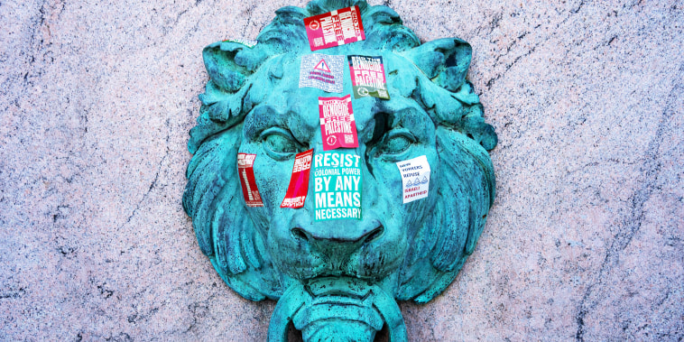 Stickers litter a statue as protestors occupy an encampment in support of Palestine on the grounds of Columbia University 