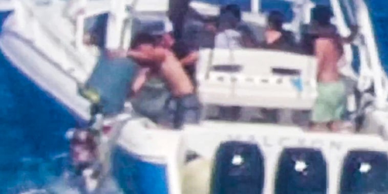 A video still of boaters dumping trash off a boat into the ocean