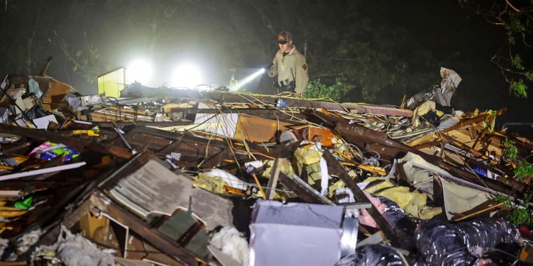 An Oklahoma State Highway Patrol trooper searches through storm damage in Barnsdall, Oklahoma.