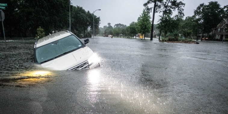 An empty car is caught in high flood waters in the rain