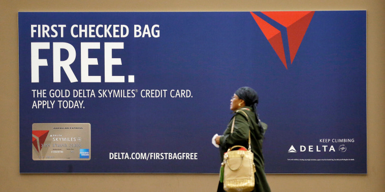 A traveler walks past a sign advertising a Delta Air Lines credit card at Seattle-Tacoma International Airport in 2015