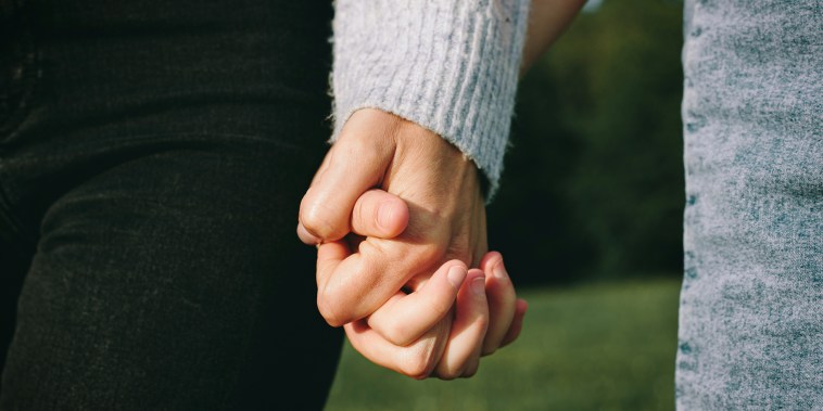 Women holding hands.