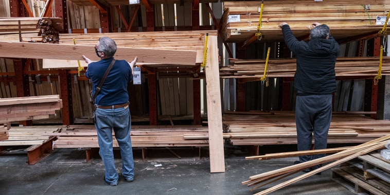 Lumber removed by two men from shelves