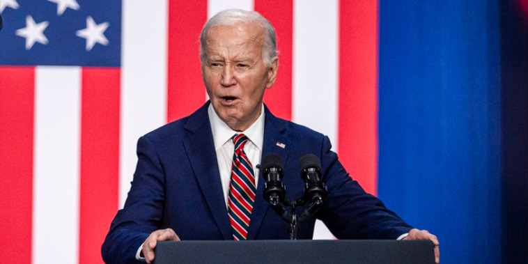 Joe Biden addresses attendees at a podium in front of an american flag