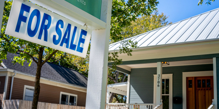 A house with a "FOR SALE" sign.