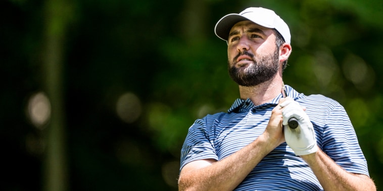 Scottie Scheffler holds a golf club over his shoulder