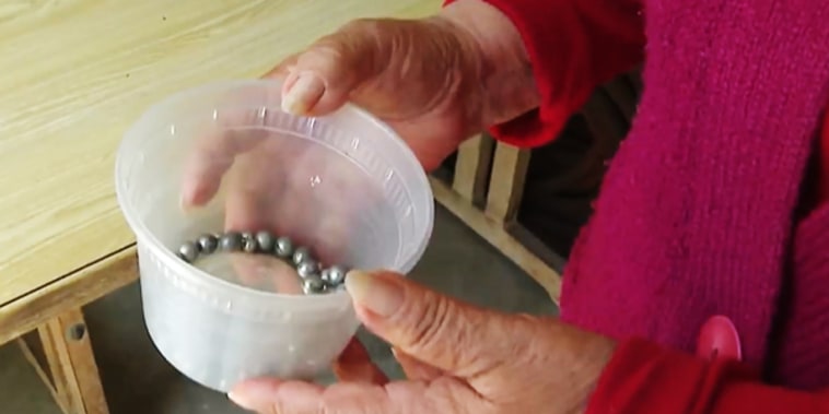 An Azusa resident holds ball bearings she says were shot at her house over the years.