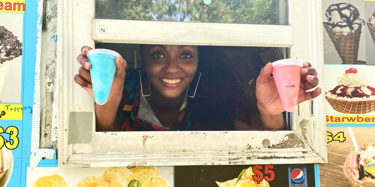 De’Nisha Beasley holds out two ice cream cones from a vendor windwo