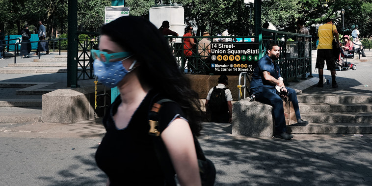 people walking around union square subway station with mask. 