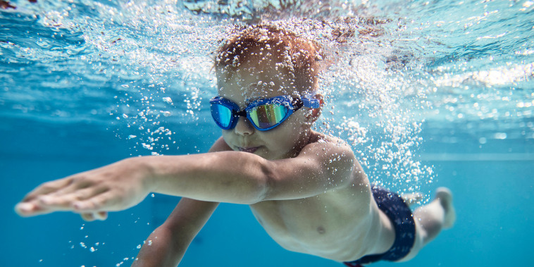 Portrait of little boy swimming underwater in the pool.