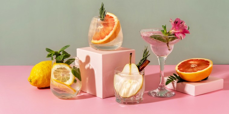 seltzers with various fruits: pear, grapefruit, lemon. Refreshing colorful spring/summer drinks on green background.