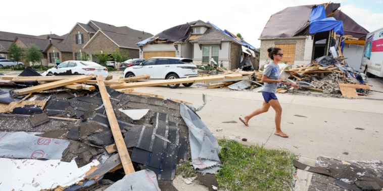 Una mujer caminaba junto a los escombros en Bridgeland mientras las familias comenzaban a limpiar los daños de la tormenta el 19 de mayo 2024, en Cypress, Texas.