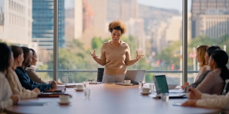 A woman leading a boardroom pitch meeting presentation in office.