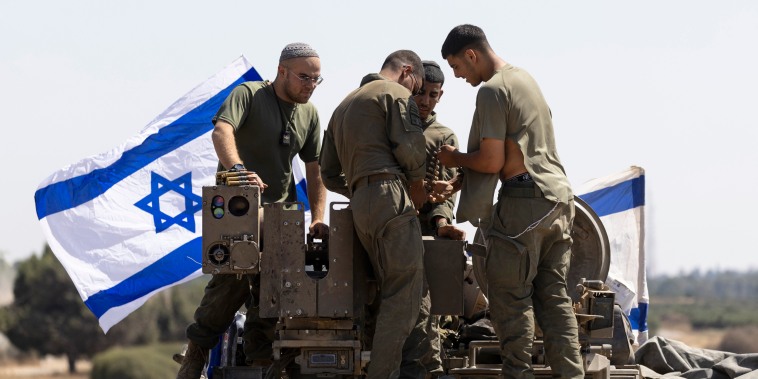 Israeli soldiers work with munitions on an armored personnel carrier near the border with the Gaza Strip on June 6, 2024 in southern Israel.