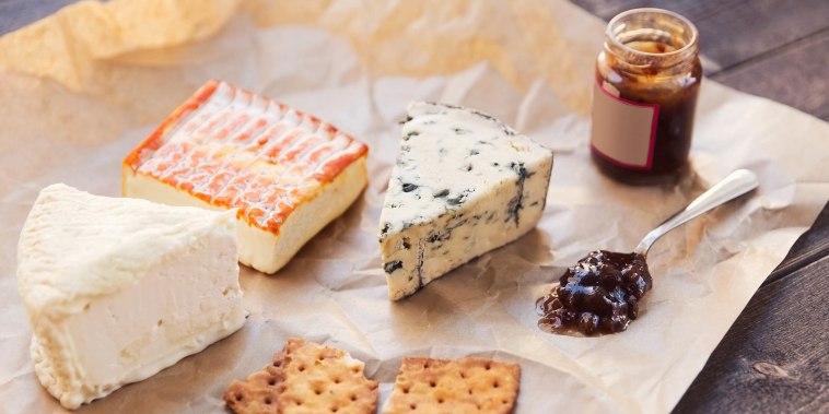 High angle view of cheese with crackers and preserves on table
