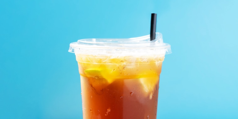 side view cup of iced tea with lemon with straw horizontal composition