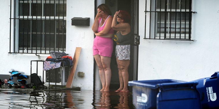 Dos mujeres reaccionan al ver inundaciones en su calle, en Miami, Florida, este jueves 13 de junio de 2024. 