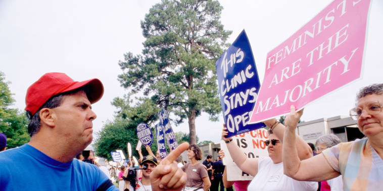 A man scowls as he confronts an abortion-rights  demonstrator outside a pregnancy center in Little Rock