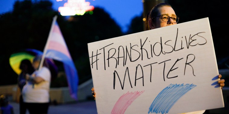 A Transgender rights advocate holds a sign outside the Ohio Statehouse during a rally, in Columbus, Ohio