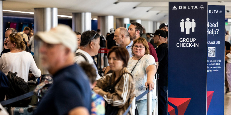 Image: Travelers wait in line at check-in in Terminal 2, Delta Airlines