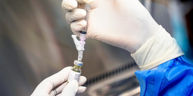 A pharmacist holds a vial of lenacapavir.