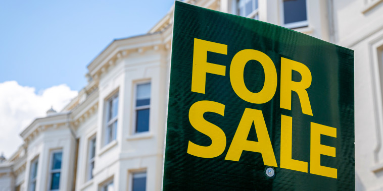 A general view of a for sale board by residential town houses.