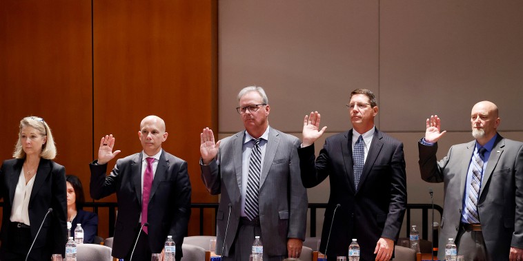 Executives stand as they are sworn -in 