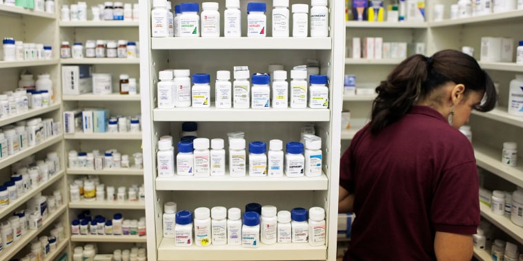 A pharmacy employee looks for medication at a pharmacy in New York