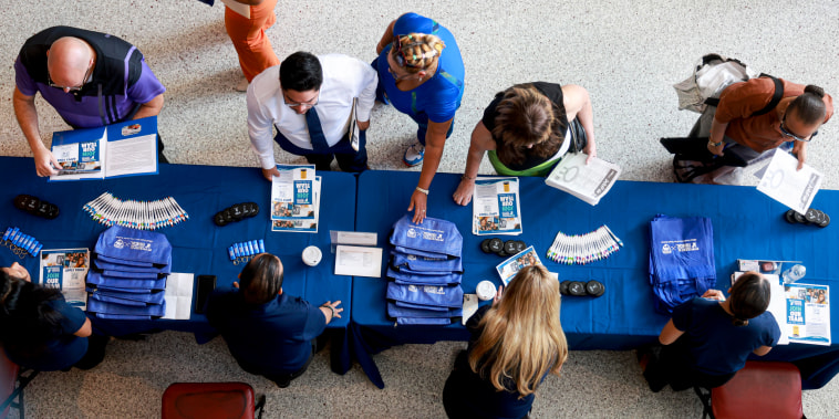 A shot from above of job seekers at an information table.