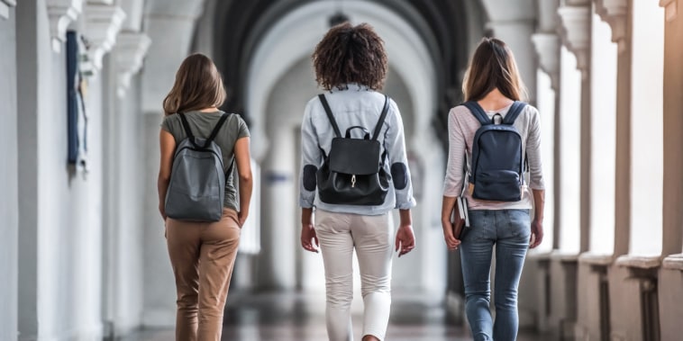 Back view students walking through the university hall