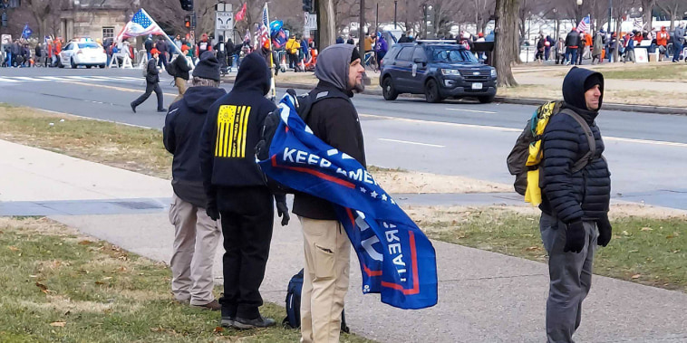 The men the FBI identified as David Walker, with a Trump flag, and Philip Walker, right, on Jan. 6, 2021. They are charged in connection with the assault on a New York Times photographer inside the Capitol building.