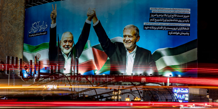 A banner with Hamas leader Ismail Haniyeh and Iranian President Masoud Pezeshkian holding hands