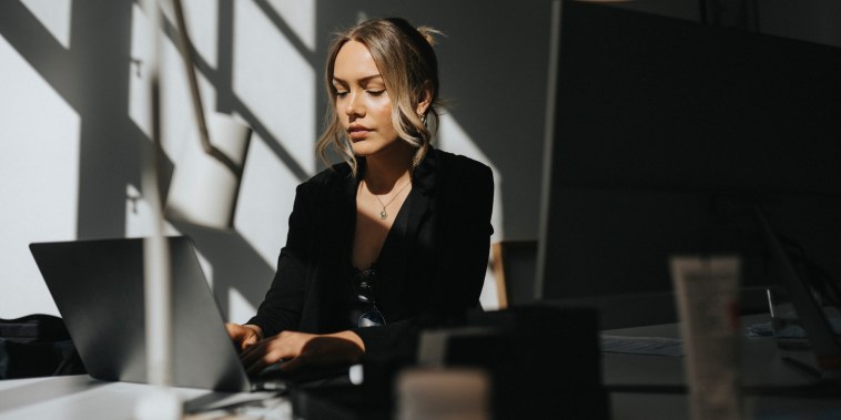 Young businesswoman working on laptop sitting at office