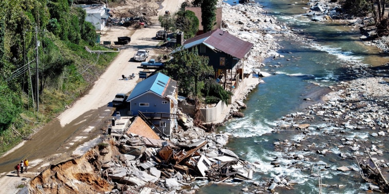 An aerial view of damaged housing near a river