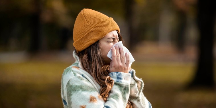 Woman sneezing in the fall