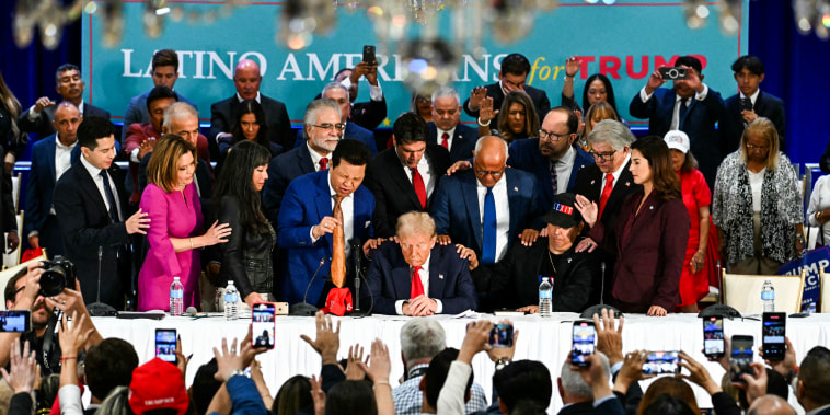 Former US President and Republican presidential candidate Donald Trump prays during a roundtable discussion with Latino community leaders in Miami, Fla. on Oct. 22, 2024.