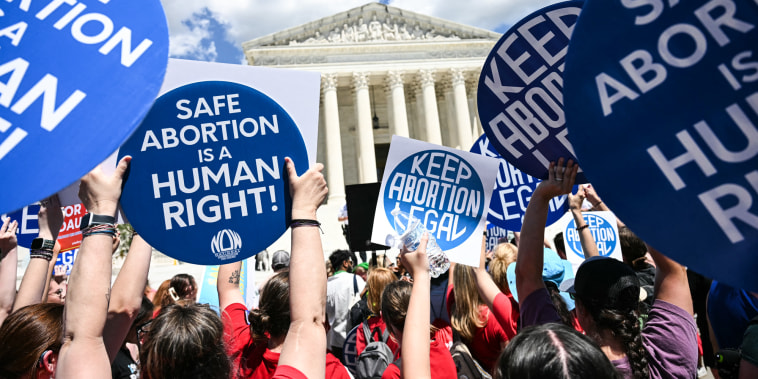 People hold signs saying "Safe Abortion is a Human Right" and "Keep abortion legal"